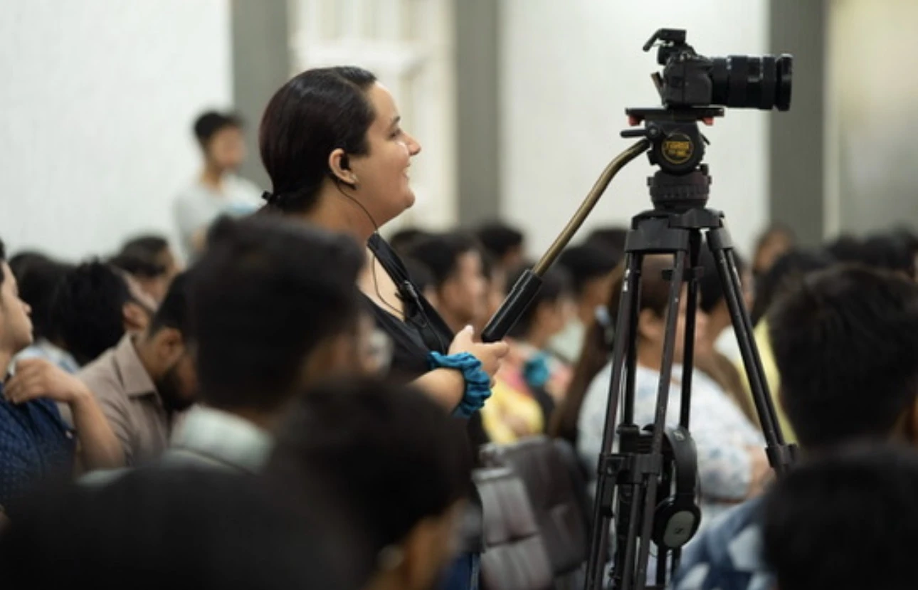 Srishti operating a camera at an event
